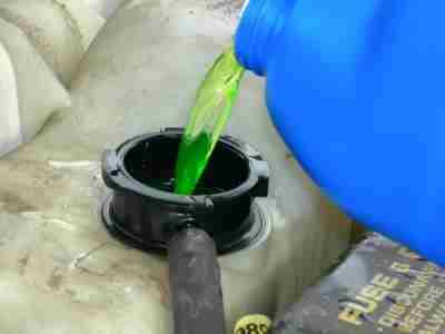 Pouring antifreeze in a car