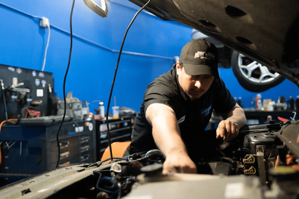 Fall car maintenance, auto repair in Rancho Santa Margarita, CA by Bobby Grich Auto Repair. Image of a technician working under the hood with focused precision, highlighting professional service to keep vehicles safe and performing reliably.