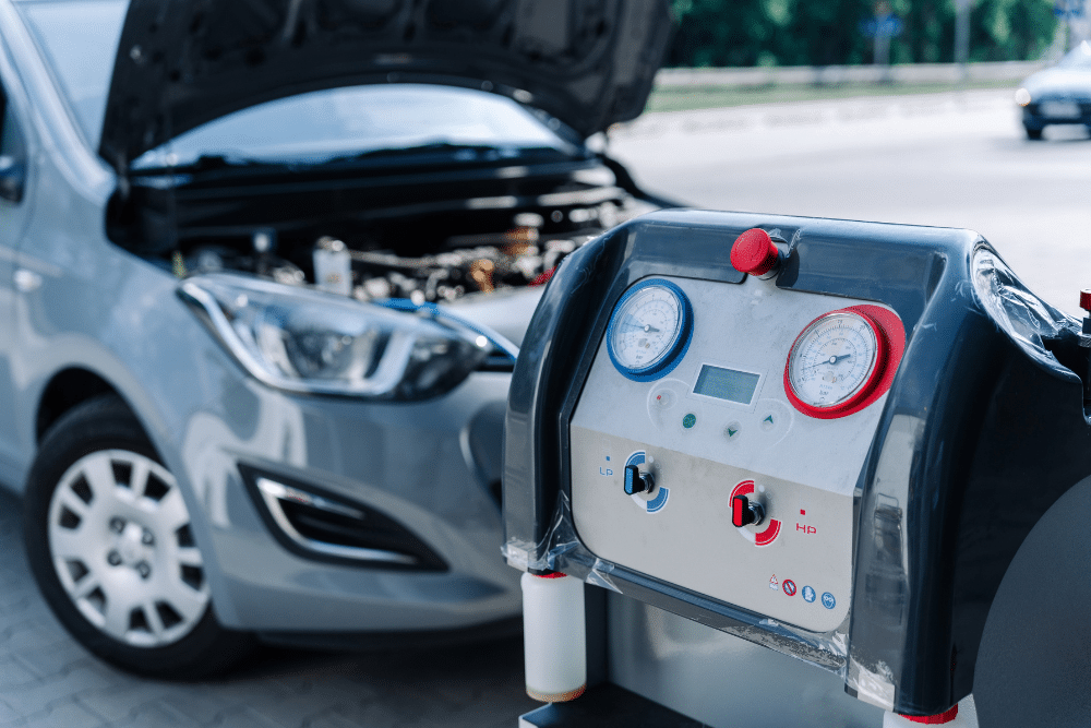 Car maintenance, auto repair in Orange, CA at Bobby Grich Auto Repair of Orange. Image of a professional automotive air conditioning machine connected to a vehicle during A/C diagnostics, refrigerant recovery, and cooling system performance testing.